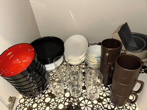 Una colección de platos, tazones y vasos apilados sobre una mesa con diseño.