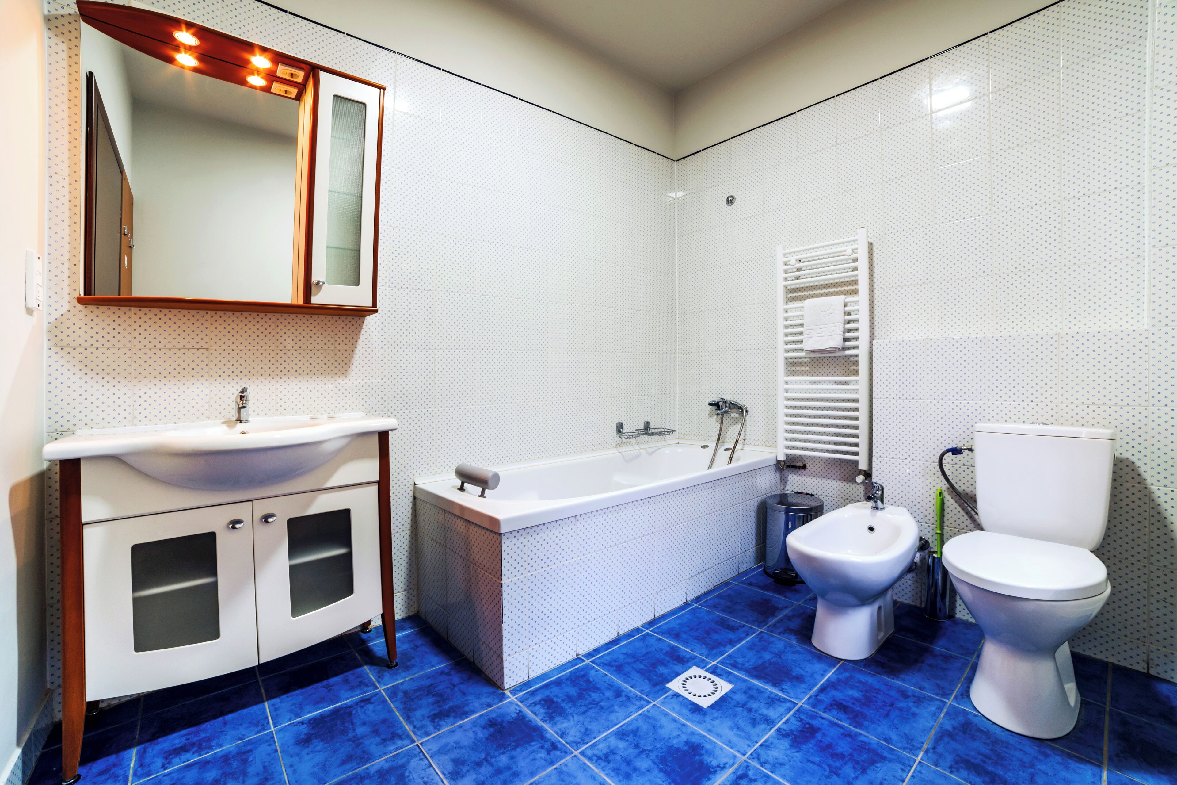 Un baño con un lavamanos blanco, una bañera, un bidé y un inodoro.