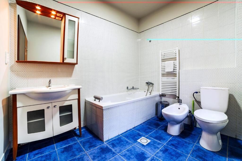 A bathroom with a white sink, a bathtub, a bidet, and a toilet.