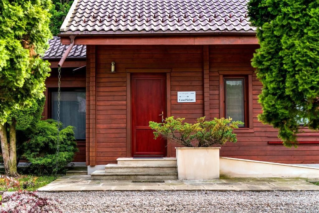 Uma casa de madeira com porta vermelha e placa indicando ser propriedade privada.