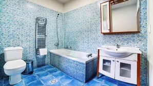 A bathroom with a white toilet, a bathtub, and a sink with a mirror above it. - Lac sub Soare (Iordacheanu)