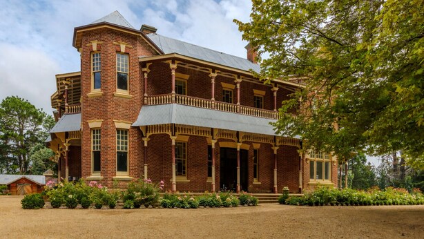 A large, two-story brick building with a balcony and a covered porch. - Burnima Cottage - situated next to Burnima Homestead at Historic Burnima Estate. (Bombala)