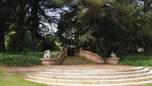 A stone staircase leading up to a bridge in a park with statues on either side. - Burnima Cottage - situated next to Burnima Homestead at Historic Burnima Estate. (Bombala)