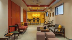 A modern living room with a sofa, chairs, a coffee table, and a chessboard. - The Hosteller Delhi, International Airport (New Delhi)
