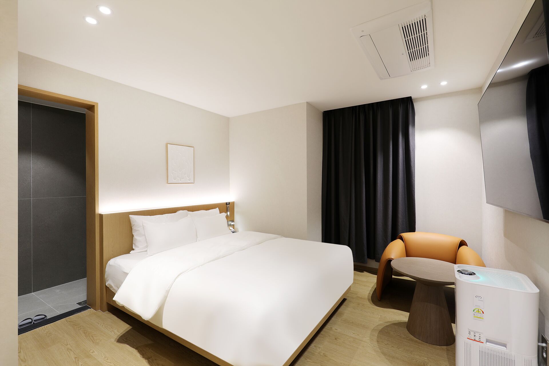 Een hotelkamer met een bed, een stoel, een tafeltje en een verwarming.