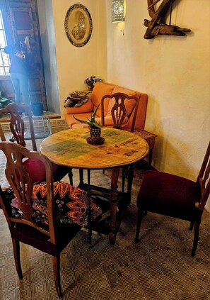 A dining area with a round table, chairs, and a patterned floor.
