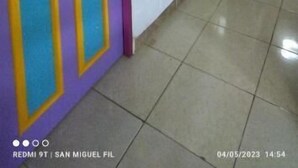 A hallway with a purple door with yellow accents, a tiled floor, and a ceiling with wooden beams. - San Miguel Filandia 2 (Filandia)