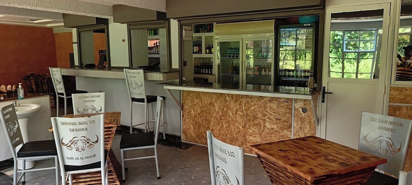 A restaurant interior with a counter, chairs, and tables.