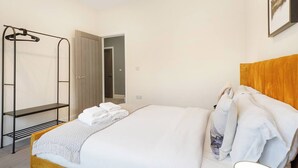 Ein Hotelzimmer mit einem Bett, einem Kleiderschrank, einem Spiegel und einer Tür zu einem Badezimmer.