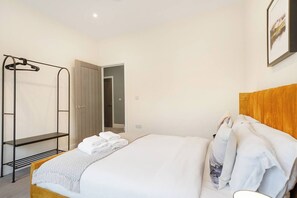 Ein Hotelzimmer mit einem Bett, einem Kleiderschrank, einem Spiegel und einer Tür zu einem Badezimmer.