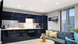Un espacio habitable moderno con cocina, un sofá y una mesa de centro.