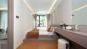 Une chambre d’hôtel moderne, équipée d’un lit, d’une coiffeuse avec un miroir et offrant une vue sur l’extérieur.