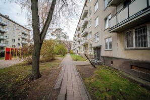 Ein Wohnweg, begrenzt von Wohngebäuden, einem Baum und einem Fahrrad.