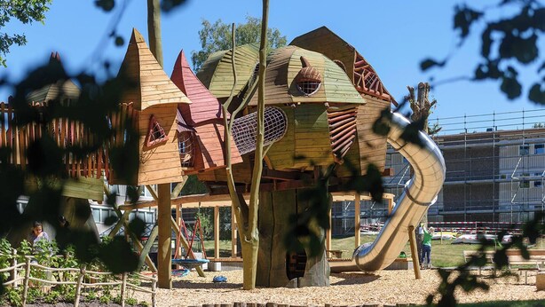 Ein Spielplatz mit Rutsche und Klettergerüsten.