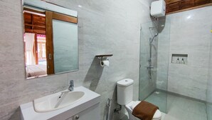A modern bathroom with a white sink, mirror, toilet, and glass-enclosed shower. - Aming Villa Balangan (Jimbaran)