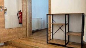 Een houten trap die leidt naar een kamer met een zwarte metalen schapkas.