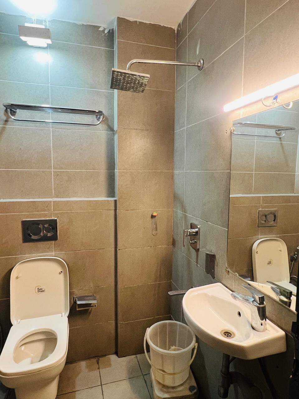Un baño con inodoro, lavabo y ducha.
