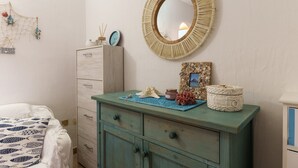 A bedroom with a bed, a dresser, a mirror, and decorative items. - Apartment 'Casa Vacanze Gelso' with Shared Pool, Private Garden and Air Conditioning (Murta Maria)