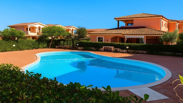 A swimming pool surrounded by a landscaped garden, with a large house in the background. - Apartment 'Casa Vacanze Gelso' with Shared Pool, Private Garden and Air Conditioning (Murta Maria)