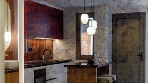 Una cucina moderna con isola centrale, mobili in legno, un lavello e sgabelli da bar.