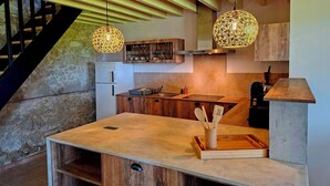 Une cuisine moderne avec des meubles en bois, un four encastré et un mur en pierre.