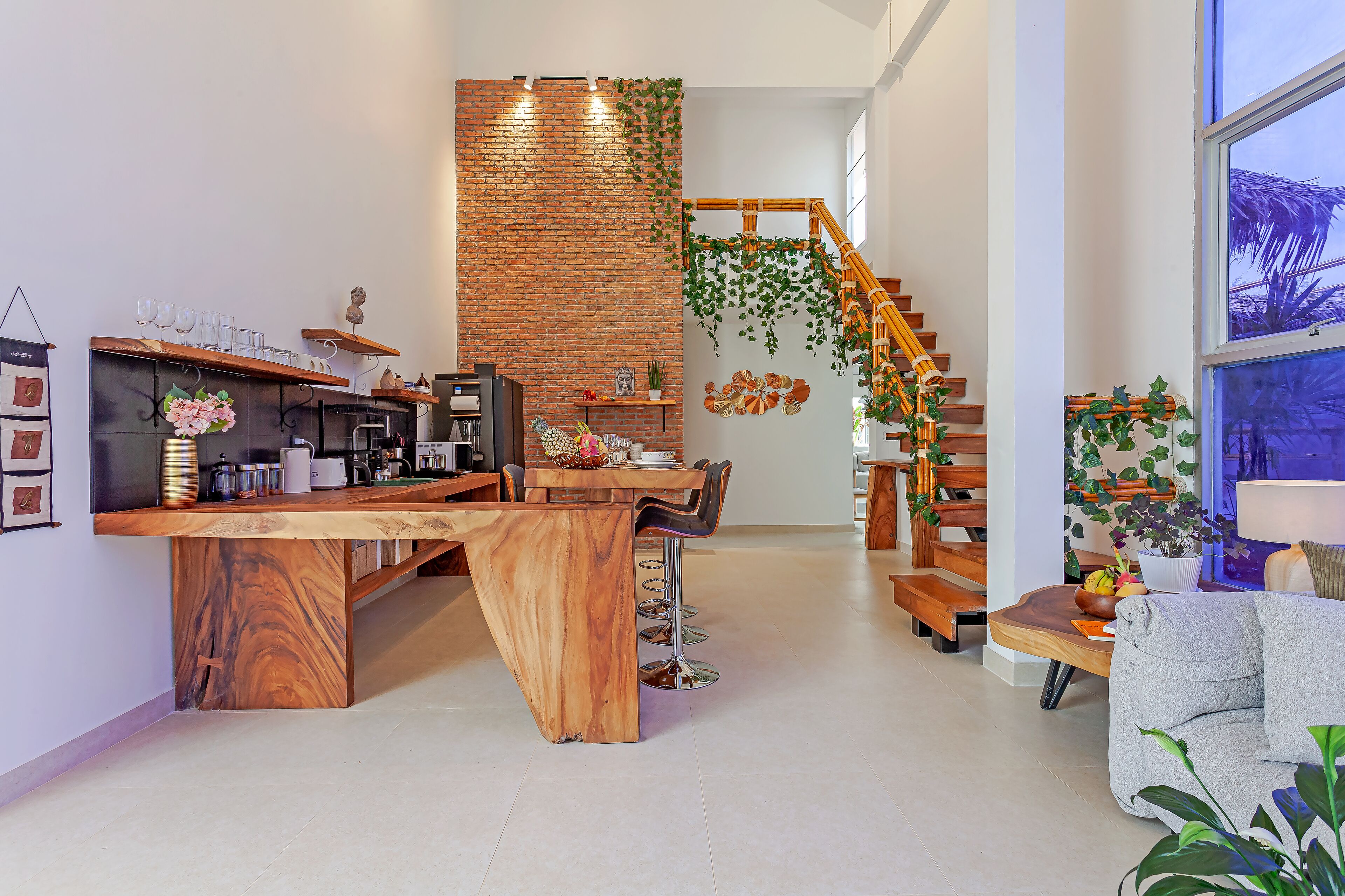 Una cocina moderna con una isla de madera, taburetes de bar y una escalera con barandilla de madera.