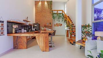 Una cocina moderna con una isla de madera, taburetes de bar y una escalera con barandilla de madera.