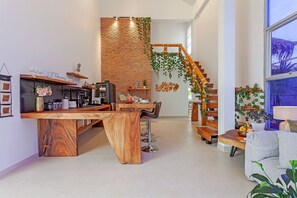 Eine moderne Küche mit einer Holzinsel, Barhocker und einer Treppe mit Holzbalkon.