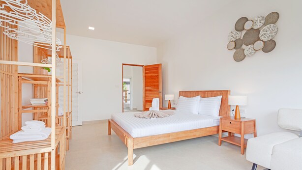 A modern bedroom with a wooden bed, a nightstand, a bedside table, and a wooden wardrobe. - Tom Star Pool Villa Layan 3BR Large pool, mountain view for the rooftop (ตำบล ศรีสุนทร)
