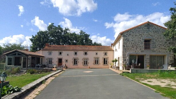 A two-story building with a stone facade and a red-tiled roof.