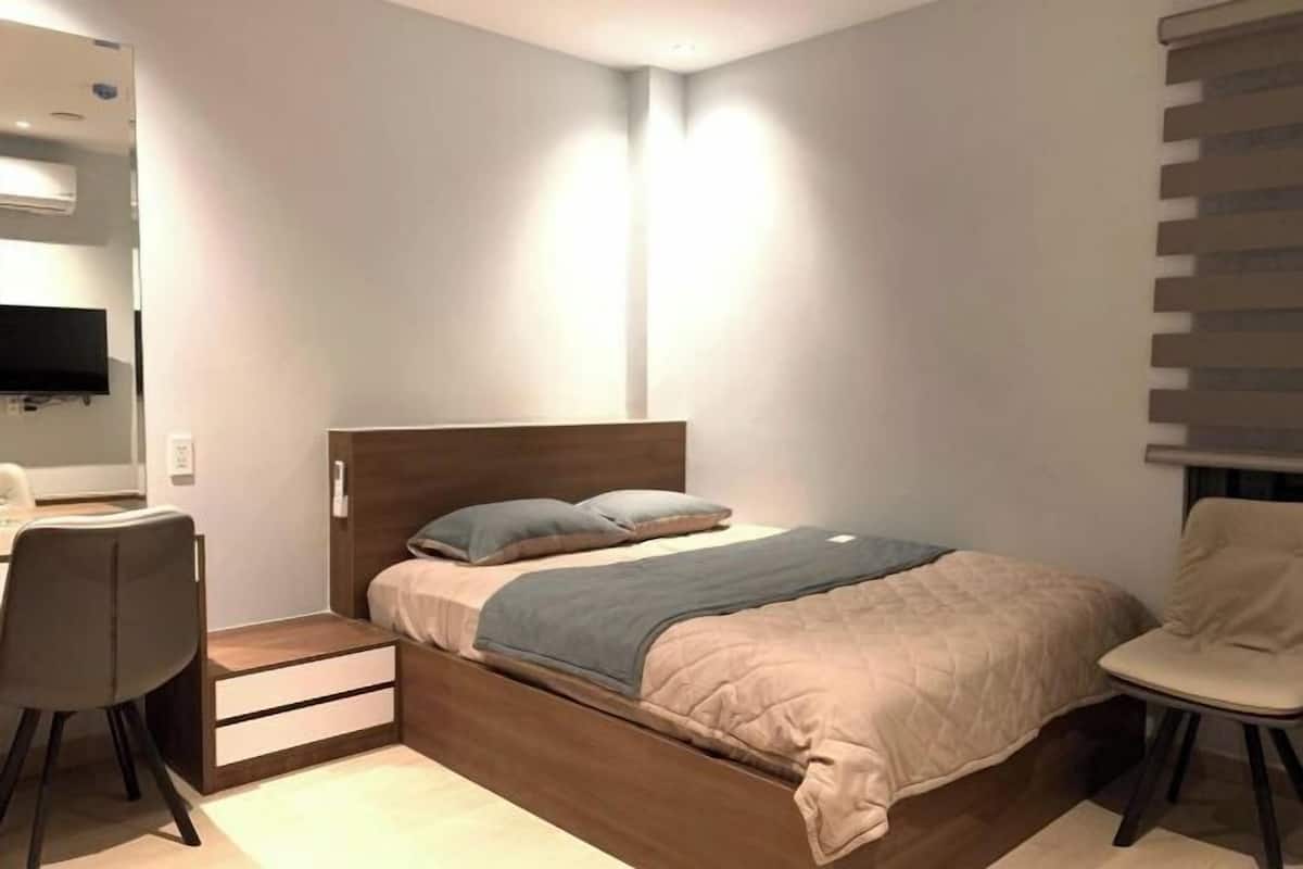 Une chambre à coucher de taille réduite, comprenant un lit, un bureau et une chaise.