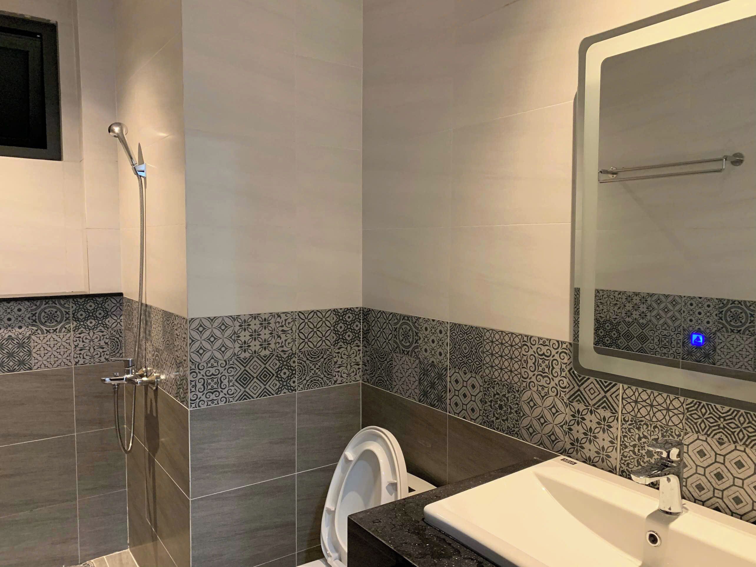 Un baño moderno con ducha, inodoro y lavamanos.