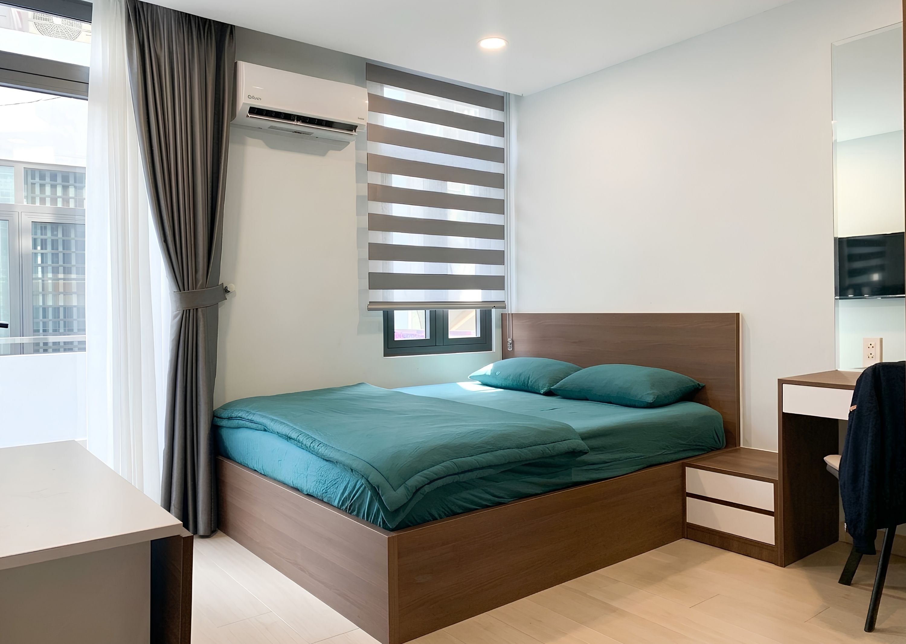 Une chambre moderne avec un lit, une table de chevet et un téléviseur encastré.