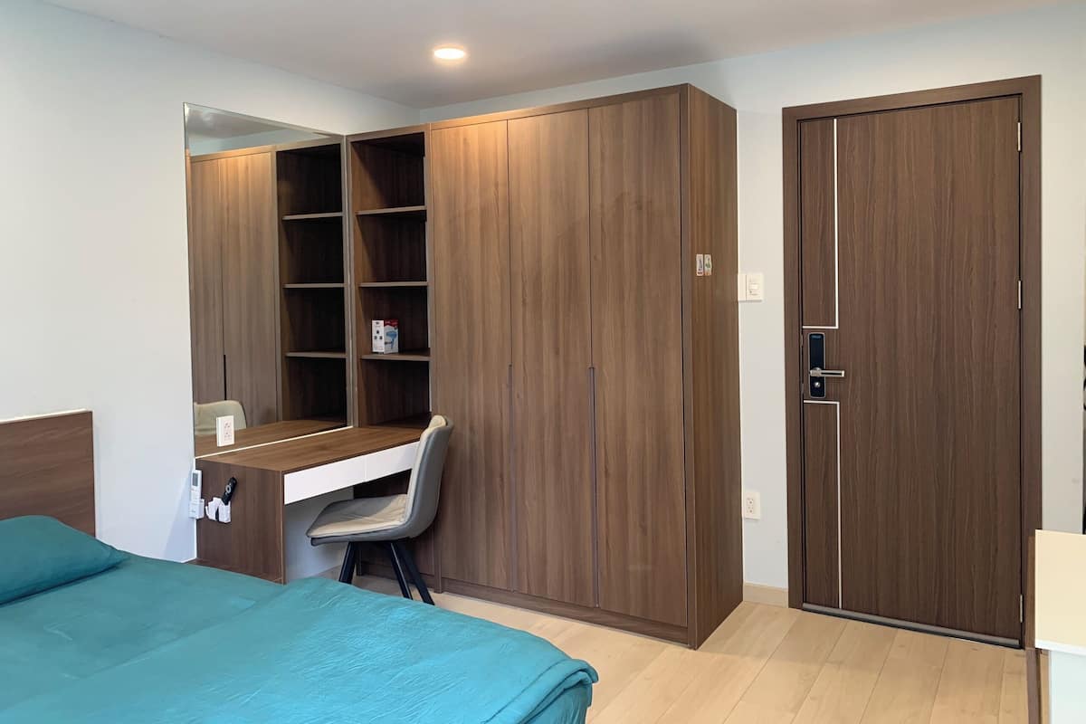 Une chambre à coucher comprenant un lit, un bureau avec une chaise et une armoire.