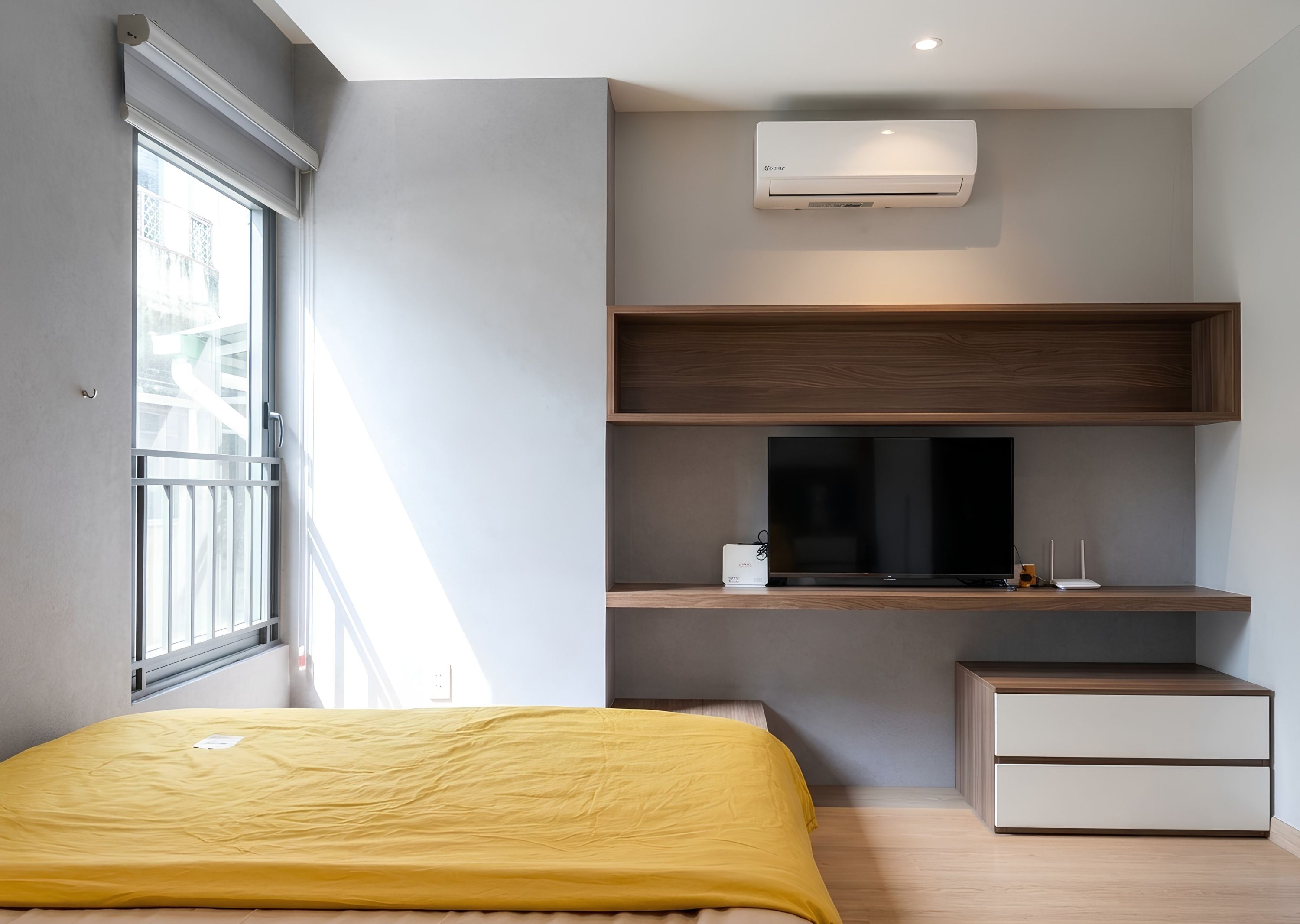 Une chambre à coucher moderne avec un lit, un téléviseur intégré et une petite table de chevet.