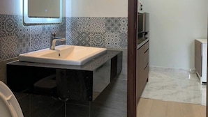 Een moderne badkamer met een grote spiegel, een wastafel en een toilet.