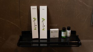 A bathroom shelf with a dental kit, comb, and two bottles of shampoo and conditioner. - Ustay (Hyderabad)
