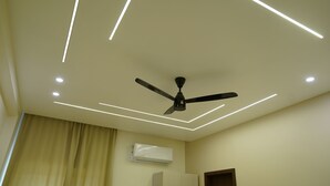 A ceiling fan with three blades, recessed lighting, and an air conditioning unit in a room. - Ustay (Hyderabad)