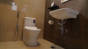 A modern bathroom with a toilet, shower, and sink. - Ustay (Hyderabad)