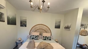 Ein Schlafzimmer mit einem großen Bett, einer Kandelaber und Kunstwerken an den Wänden.