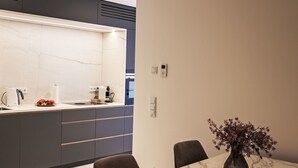 A modern kitchen with a marble countertop, a coffee machine, and a plate of fruit. - Munich Finest Apartments 16 by Interhome (Munich)