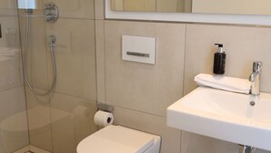 A modern bathroom with a toilet, bidet, and shower. - Munich Finest Apartments 19 by Interhome (Munich)