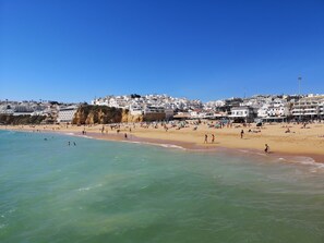 Un pueblo costero con una playa de arena y aguas azul turquesa.