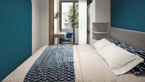 A modern hotel room with a bed, a desk, and a chair. There is a view of the outdoors through a window. - Lumiere Urban Apartment (Ho Chi Minh City)