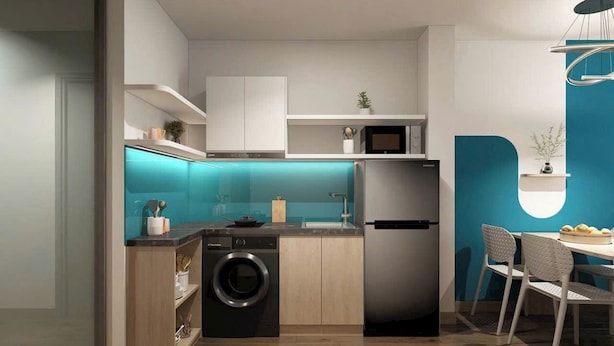 A modern kitchen with a washing machine, a refrigerator, and a dining area with chairs. - Lumiere Urban Apartment (Ho Chi Minh City)