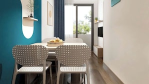A modern dining area with a round table, two perforated chairs, a blue accent wall, a hanging light fixture, and a view through a glass door. - Lumiere Urban Apartment (Ho Chi Minh City)