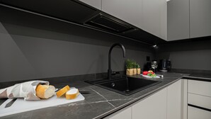 A modern kitchen with a black sink, white cabinets, and a marble countertop. - Italianway Comfort - Monte Nevoso 8 (Milan)