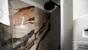 A bathroom with a shower and a marble wall. - Italianway Comfort - Monte Nevoso 8 (Milan)