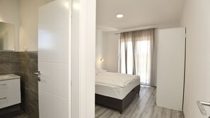 A hotel room with a bathroom, a bed, and a wardrobe. - Villa Marica-Grubine by Villas Guide (Grubine)
