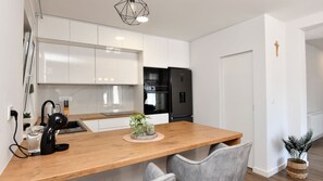 A modern kitchen with white cabinets, a black refrigerator, a wooden countertop, and a small plant. - Villa Marica-Grubine by Villas Guide (Grubine)